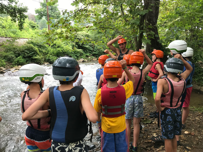 Boys attentively listening to their counselor’s instructions during a paddling trip.