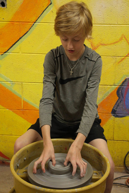 Throwing pots on the wheel in Pottery