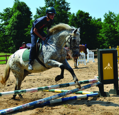 Camper jumping a horse at Falling Creek Camp.