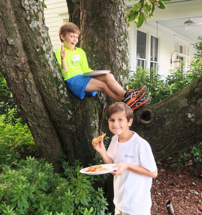 Hartt and Teddy greeting families as they arrive and enjoying their pizza.