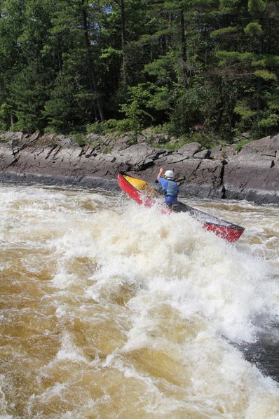 Andy Suleskey paddling hard through a large rapid in his open boat.